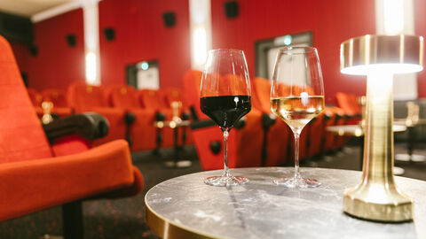 Weingläser auf einem Tisch in einem Kinosaal