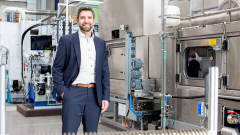 Prof. Dr. Matthias Weigold erhält an der TU Darmstadt eine Transfer-Professur für Klimaneutrale Produktion. Prof. Dr. Matthias Weigold steht vor großen Gerätschaften zur wissenschaftlichen Forschung.