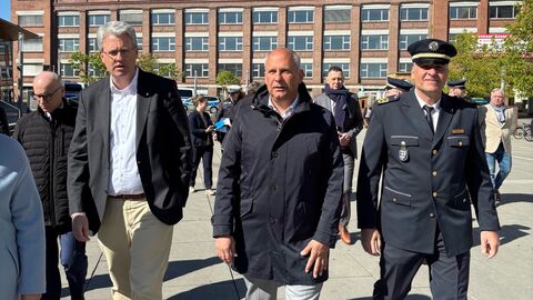 Innenminister Poseck und weitere Personen laufen über einen Platz.