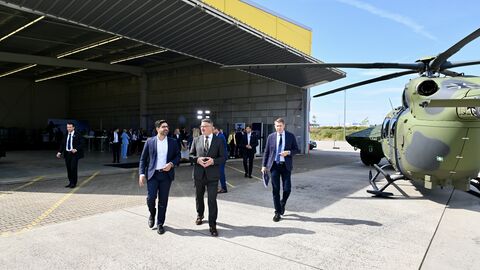 Einige Personen laufen über einen Platz, im Hintergrund ist ein Hubschrauber zu sehen.