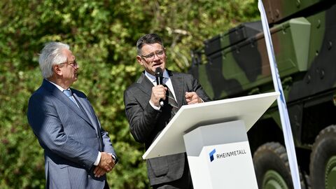 Zwei Personen stehen an einem Rednerpult und sprechen. 