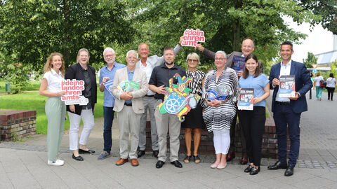 Vorstellung Digitalhandbuch Der Chef der Staatskanzlei, Staatsminister Axel Wintermeyer, und Landrat Oliver Quilling gemeinsam mit einer Gruppe Vertreterinnen und Vertreter der Vereine und der LandesEhrenamtsagentur Hessen auf einem Platz.