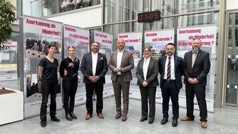 Eröffnung der Ausstellung „Der Weg der Sinti und Roma“ Innenminister Roman Poseck unter anderem mit dem stellvertretenden Geschäftsführer des Landesverbades Hessen Deutscher Sinti und Roma Rinaldo Strauß, der Vizepräsidentin des Polizeipräsidiums Südosthessen und weiteren Bediensteten des Polizeipräsidiums Südosthessen. Sie stehen gemeinsam vor Aufstellern der Ausstellung.