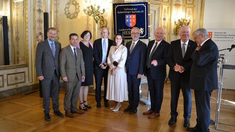 75 Jahre Landesverband der Siebenbürger Sachsen Mehrere Männer und zwei Frauen stehen zusammen und lächeln in Kamera.